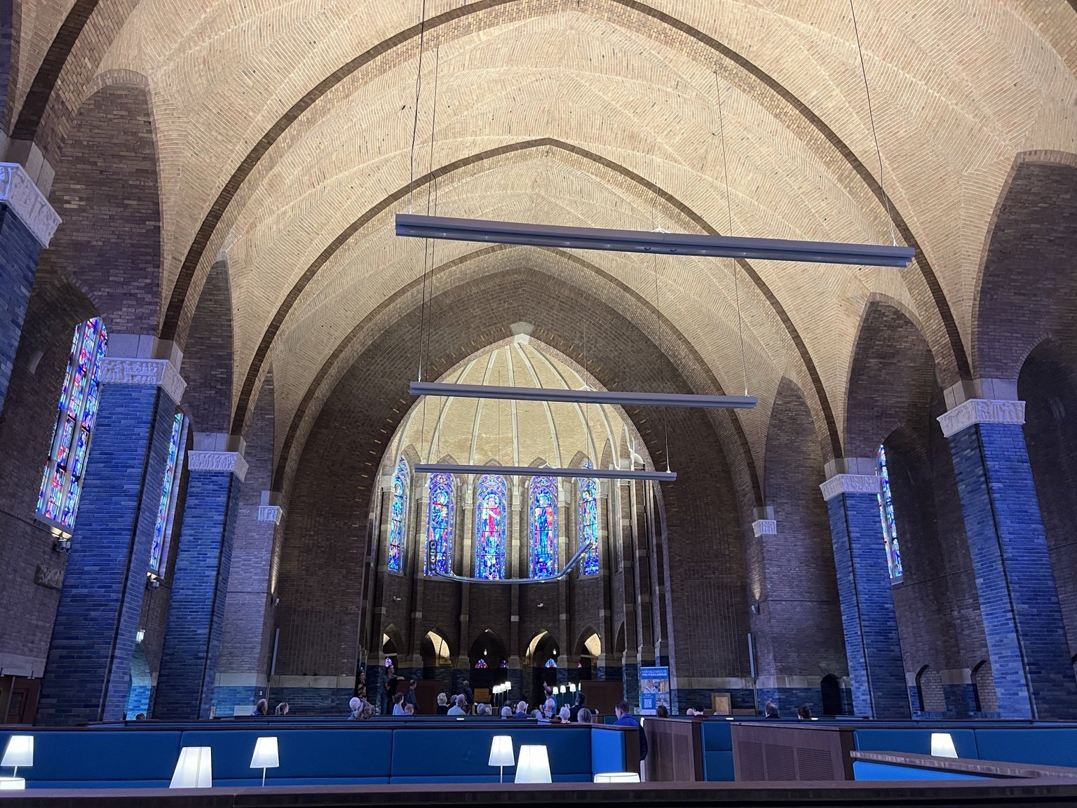Brick vaults, stained-glass windows and blue seating inside the chapel at the Police Academy in Apeldoorn.